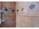 Custom tiled shower featuring both standard and rainfall shower heads and decorative tile accents at 2005 Country Club Dr, Port Orange, FL 32128