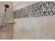 Detailed shot of a modern shower with unique tile accents, a handheld showerhead, and a built-in shelf at 2005 Country Club Dr, Port Orange, FL 32128