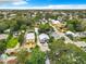 Aerial view showcases the community with mature trees, nearby rooftops, and streetscape at 216 Murray St, New Smyrna Beach, FL 32168