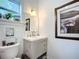 Cozy bathroom has a stylish vanity, window, and framed artwork at 216 Murray St, New Smyrna Beach, FL 32168