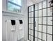 Bright bathroom features a modern shower with black grid doors and a view to tropical foliage at 216 Murray St, New Smyrna Beach, FL 32168
