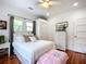 Inviting bedroom with a cozy bed, wicker furniture, and sunlit windows with shades at 216 Murray St, New Smyrna Beach, FL 32168