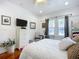 Comfortable bedroom with hardwood floors, a television, and pleasant natural light at 216 Murray St, New Smyrna Beach, FL 32168