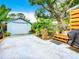 Detached garage with ample parking space, complemented by a cozy wooden deck and lush landscaping at 216 Murray St, New Smyrna Beach, FL 32168