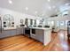 Open-concept kitchen seamlessly flowing into the living area, featuring stainless steel appliances and gray cabinets at 216 Murray St, New Smyrna Beach, FL 32168