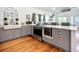 Stylish kitchen with stainless steel appliances, gray cabinets, quartz countertops, and a wine cooler at 216 Murray St, New Smyrna Beach, FL 32168