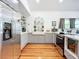 Modern kitchen featuring stainless steel appliances, gray cabinets, a farmhouse sink, and hardwood floors at 216 Murray St, New Smyrna Beach, FL 32168