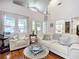 A spacious living room with large windows, white walls, and hardwood floors, offering a bright and airy feel at 216 Murray St, New Smyrna Beach, FL 32168