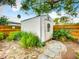 Backyard shed with a white exterior and a decorative wreath on the door, surrounded by lush greenery at 216 Murray St, New Smyrna Beach, FL 32168