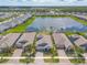 Aerial view of the neighborhood showcasing beautiful homes surrounding a serene lake with lush greenery at 219 Venetian Palms Blvd, New Smyrna Beach, FL 32168