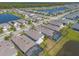 An aerial view shows homes, lawns, community ponds, and the tree line in a well planned community at 219 Venetian Palms Blvd, New Smyrna Beach, FL 32168