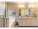 Well lit bathroom featuring a large tub, walk in shower, and double vanity with granite counters and wood-look tile at 219 Venetian Palms Blvd, New Smyrna Beach, FL 32168