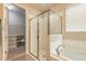 Bright bathroom featuring a glass shower, tiled tub, and entry to a closet with lots of shelving at 219 Venetian Palms Blvd, New Smyrna Beach, FL 32168