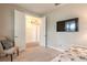 Comfortable bedroom with TV and walk-in closet offers ample space, natural light, and neutral tones at 219 Venetian Palms Blvd, New Smyrna Beach, FL 32168