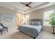 Inviting bedroom with a tray ceiling, soft carpet, and lots of natural light from the large windows at 219 Venetian Palms Blvd, New Smyrna Beach, FL 32168