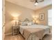 Cozy bedroom with a ceiling fan, lamps on bedside tables, and a window, creating a peaceful retreat at 219 Venetian Palms Blvd, New Smyrna Beach, FL 32168