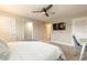 Bedroom featuring a ceiling fan, television, and multiple entry doors at 219 Venetian Palms Blvd, New Smyrna Beach, FL 32168