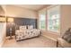 Cozy bedroom featuring a daybed with decorative pillows, large windows, and neutral decor at 219 Venetian Palms Blvd, New Smyrna Beach, FL 32168