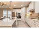 Beautiful kitchen with white cabinetry, stainless steel appliances, an island with a sink, and stylish lighting at 219 Venetian Palms Blvd, New Smyrna Beach, FL 32168