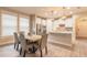 Open-concept dining area next to a bright kitchen, featuring hardwood floors and stainless steel appliances at 219 Venetian Palms Blvd, New Smyrna Beach, FL 32168