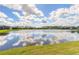 Picturesque lake view reflecting blue sky and clouds, enhancing the serene outdoor experience at 219 Venetian Palms Blvd, New Smyrna Beach, FL 32168