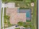 Bird's eye view of a home featuring a screened pool, tile roof, landscaped yard, and paved driveway at 254 Cappella Ct, New Smyrna Beach, FL 32168