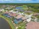 Aerial view showcasing homes with pools and well-maintained lawns in a community with water features at 254 Cappella Ct, New Smyrna Beach, FL 32168