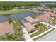 Aerial view of a home with a pool, a well-manicured lawn, and a lake view at 254 Cappella Ct, New Smyrna Beach, FL 32168