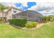 Beautifully landscaped backyard with mature plantings and a screened-in pool at 254 Cappella Ct, New Smyrna Beach, FL 32168