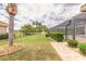 Well-maintained backyard with lush landscaping, a pond view, and a screened lanai at 254 Cappella Ct, New Smyrna Beach, FL 32168