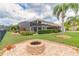 Landscaped backyard with firepit and mature trees enhances this lakefront property at 254 Cappella Ct, New Smyrna Beach, FL 32168