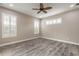 Spacious bedroom featuring wood-look flooring, neutral paint, and multiple windows with plantation shutters at 254 Cappella Ct, New Smyrna Beach, FL 32168