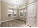 Bright breakfast nook with three windows, plantation shutters, and hardwood-style tile flooring at 254 Cappella Ct, New Smyrna Beach, FL 32168