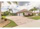 Paver driveway with attached two car garage surrounded by mature landscaping at 254 Cappella Ct, New Smyrna Beach, FL 32168