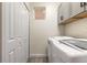 Bright laundry room with cabinets, a hexagon tile backsplash, and modern washer and dryer at 254 Cappella Ct, New Smyrna Beach, FL 32168
