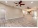 Expansive living area featuring wood-look tile floors, two ceiling fans and staircase at 254 Cappella Ct, New Smyrna Beach, FL 32168