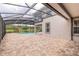 Large brick patio area with a screened-in pool and view of the green space at 254 Cappella Ct, New Smyrna Beach, FL 32168