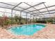 Inviting in-ground pool inside screened lanai surrounded by brick pavers and lush plants at 254 Cappella Ct, New Smyrna Beach, FL 32168