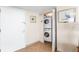 Hallway with stackable washer and dryer in a closet, tile flooring, and light walls at 2625 S Atlantic Ave # 18Nw, Daytona Beach, FL 32118