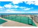 Outdoor tennis court with ocean views, seating, and lush landscape on a sunny day at 2625 S Atlantic Ave # 18Nw, Daytona Beach, FL 32118