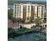 Expansive aerial view of a luxury building complex, lush greenery, tennis court, and waterfront scenery at 265 Minorca Beach Way # 902, New Smyrna Beach, FL 32169