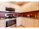 Renovated kitchen featuring stainless steel appliances, granite countertops, and white cabinetry at 265 Minorca Beach Way # 902, New Smyrna Beach, FL 32169