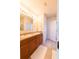 Bathroom features a double sink vanity with tan countertop and a large mirror at 2818 Taton Trce, New Smyrna Beach, FL 32168