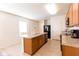 Bright kitchen with wood cabinets, central island, and black appliances offers ample counter space at 2818 Taton Trce, New Smyrna Beach, FL 32168