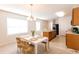 Open-concept kitchen and dining area with wood cabinets, black appliances, and a cozy breakfast table at 2818 Taton Trce, New Smyrna Beach, FL 32168