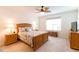 Main bedroom showcasing a patterned bedspread, ceiling fan, bedside tables, and window at 2818 Taton Trce, New Smyrna Beach, FL 32168