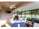 Enclosed patio featuring a dining set, lounge chairs, and fan with peaceful outdoor view at 2818 Taton Trce, New Smyrna Beach, FL 32168