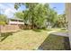 Large backyard featuring a grassy lawn, mature trees, and a privacy fence at 2822 Brookline Ave, New Smyrna Beach, FL 32168