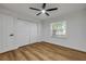 Bright bedroom features wood-look flooring, a ceiling fan, and a double-door closet at 2822 Brookline Ave, New Smyrna Beach, FL 32168