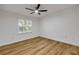 Neutral bedroom featuring a window, ceiling fan and wood-look floors at 2822 Brookline Ave, New Smyrna Beach, FL 32168